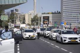 Israelíes se paran junto a sus autos en una calle concurrida mientras las sirenas suenan durante dos minutos en recuerdo de las víctimas del Holocausto, en Tel Aviv, Israel.