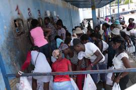Decenas de personas reunidas frente a la Penitenciaría Nacional de Haití, en el centro de Puerto Príncipe, aguardando su turno para entregar alimentos a sus familiares encarcelados.