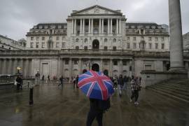 Una mujer con un paraguas se para frente al Banco de Inglaterra, en el distrito financiero de Londres, el 3 de noviembre de 2022. (AP Foto/Kin Cheung, Archivo)