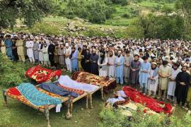 Un grupo de personas realiza oraciones fúnebres por quienes fallecieron en una inundación repentina provocada por las lluvias torrenciales, en Salarzai, Pakistán, el viernes 15 de agosto de 2025.