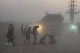 Los palestinos corren hacia camiones que transportan ayuda humanitaria del Programa Mundial de Alimentos.