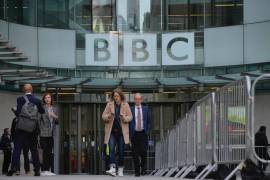 La gente camina frente a la sede de la BBC en Londres mientras la BBC celebra 100 años de transmisión.