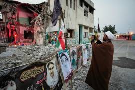 Un clérigo toma una foto en la destruida escuela Shajareh Tayyebeh, que se ha convertido en un lugar de duelo y recuerdo a los muertos en un ataque aéreo estadounidense el 8 de febrero en Minab, en el sur de Irán.