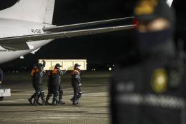 Un grupo de trabajadores trasladan el féretro de una de las víctimas de la caída del avión de Azerbaijani Airlines, cerca de la ciudad de Aktau, en Kazajstán, a su llegada al Aeropuerto Internacional Heydar Aliyev, en las afueras de Bakú, Azerbaiyán. FOTO: