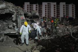 Unas personas transportan un cadáver rescatado de un edificio que se derrumbó a causa de los terremotos en La Guaira, Venezuela, el jueves 30 de julio de 2026.