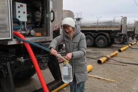 Una mujer recibe agua potable distribuida por las autoridades en la ciudad de Donetsk, en la zona del este de Ucrania controlada por Rusia, el jueves 19 de febrero de 2026.