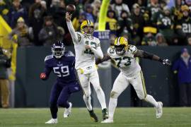 Aaron Rodgers (12), quarterback de los Packers de Green Bay, lanza un pase mientras el tackle ofensivo Yosh Nijman (73) ayuda ante la presión del tackle defensivo de los Titans de Tennessee, Sam Okuayinonu (59).