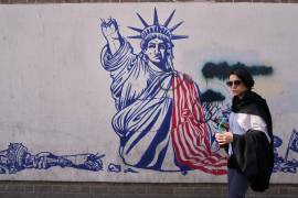 Una mujer pasa junto a un mural antiestadounidense en la pared de la antigua embajada de Estados Unidos, ahora museo, en Teherán, Irán, el viernes 12 de junio de 2026.