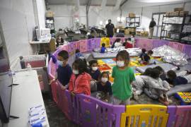 30 de marzo de 2021. Niños migrantes no acompañados ven la televisión dentro de un corralito en el centro de detención de la Oficina de Aduanas y Protección Fronteriza en Donna, Texas.