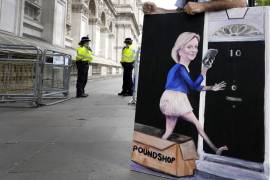 El artista Kaya Mar muestra su pintura de la líder del Partido Conservador de Gran Bretaña, Liz Truss, en Whitehall en Londres.