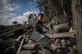 Un niño palestino inspecciona entre los escombros de un edificio destruido tras un ataque aéreo israelí en Deir Al Balah, en el centro de la Franja de Gaza, 4 de octubre de 2024.