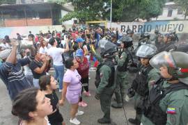 Personas reclaman frente a integrantes de la Guardia Nacional Bolivariana en una manifestación luego de los resultados de las elecciones presidenciales en Caracas.