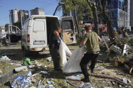 Personal de rescate ucraniano retira el cuerpo de una víctima de los bombardeos rusos del sábado en Járkiv.