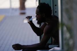 Una persona bebe una botella de agua a la sombra mientras se espera que las temperaturas alcancen los 48.3 grados Celsius el 20 de julio de 2023 en Phoenix.