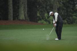 Tiger Woods conecta un fairway en el hoyo 18 en la segunda ronda del Masters que se aplazó al sábado debido a una tormenta en el Augusta National Golf Club.