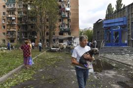 Los residentes de un edificio de apartamentos dañado tras un bombardeo del lado ucraniano abandonan el área en Kursk, Rusia