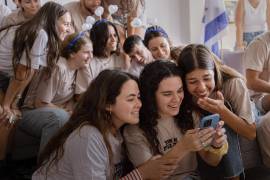 Los amigos de Alon Ohel hablando con su familia en una videollamada tras recibir la noticia de su regreso a Israel desde Gaza el lunes.