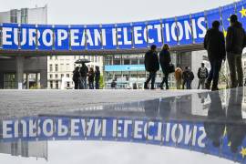 La gente pasa junto a anuncios para las próximas elecciones de la UE de 2024 frente al edificio del Parlamento Europeo en Bruselas, Bélgica.