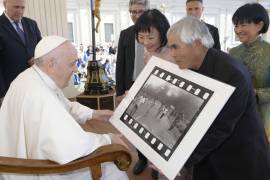 El fotógrafo vietnamita-estadounidense Nick Ut (c) mostrando su premio Pulitzer y World Press Photo Award, fotografía de 1972 ‘Napalm Girl’, al Papa Francisco (i) en Ciudad del Vaticano.
