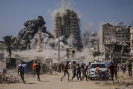 Palestinos corren para protegerse durante un ataque aéreo israelí contra un edificio de gran altura en la Ciudad de Gaza, el viernes 5 de septiembre de 2025, después de que Israel lanzara una advertencia previa.