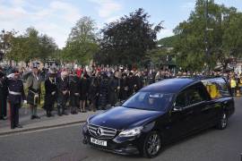 Ciudadanos en Ballater, Escocia, al paso del auto fúnebre de la reina Isabel II en su recorrido desde Balmoral a Edimburgo.