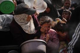 Los palestinos tienen dificultades para recibir alimentos donados en un comedor comunitario en Nuseirat, en el centro de la Franja de Gaza.