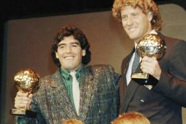 La estrella argentina Diego Maradona, izquierda, y el portero de Alemania Occidental Harald Schumacher sostienen sus trofeos de la Copa Mundial de Fútbol.