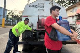 Bryan Pérez carga un bidón de cinco galones de agua hacia su apartamento en el complejo de vivienda pública Villa Kennedy, en San Juan, Puerto Rico, el 10 de junio de 2026.