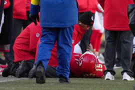Kansas City Chiefs quarterback Patrick Mahomes (15) is checked on after being injured during the second half of an NFL football game against the Los Angeles Chargers Sunday, Dec. 14, 2025, in Kansas City, Mo. (AP Photo/Ed Zurga)