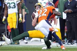 Luke Musgrave, atrás, ala cerrada de los Packers de Green Bay, fue golpeado por el safety de los Broncos de Denver, Kareem Jackson.
