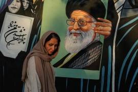 Una mujer pasa frente a un mural que muestra un retrato del fallecido Líder Supremo de Irán, el ayatolá Ali Jamenei —quien murió en un ataque de Estados Unidos e Israel el 28 de febrero—, en el centro de Teherán, Irán, el sábado 18 de julio de 2026.