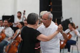 Parejas bailan al ritmo de los boleros durante el concierto de la Orquesta Filarmónica del Desierto en la Unidad Deportiva Carlos R. González.