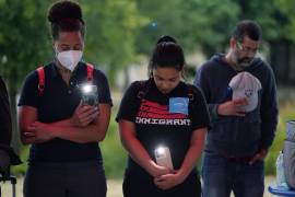 Naiyolis Paloma (c) y otros rezan durante una vigilia por las decenas de personas muertas halladas en un semirremolque en San Antonio, Texas.