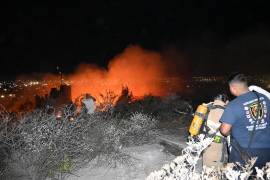 Elementos del Cuerpo de Bomberos inspeccionan los restos de la vivienda consumida por el incendio en la colonia Veteranos de la Revolución.