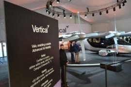 Unas personas observan a un taxi volador eléctrico de la compañía Vertical Aerospace expuesto en Miami Beach, Florida.