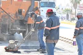 ersonal de Obras Públicas aplica asfalto en uno de los tramos más afectados de la vía.