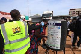 Varias personas se desinfectan las manos mientras un trabajador sanitario comprueba la temperatura de viajeros que cruzan de Uganda a Kenia, como parte de las medidas para contener la propagación del virus del ébola, en Busia, Kenia, el 15 de octubre de 2026.