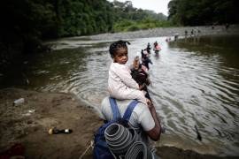 Migrantes cruzan el río Turquesa en la selva de Darién, en Panamá. Según datos oficiales proporcionados por Panamá, cerca de 400,000 personas habían cruzado el Darién hasta septiembre de 2023.