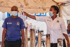 Una trabajadora de la salud revisa la temperatura de una persona en una clínica temporal en el cruce fronterizo de Mpondwe que conecta Uganda y la República Democrática del Congo, el 4 de junio de 2026.