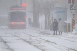 Personas caminan durante una nevada este domingo, en Toronto, Canadá.