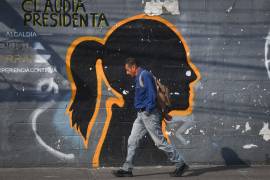 Un hombre camina frente a un mural desgastado de la silueta del perfil de Claudia Sheinbaum, presidenta de México, ubicado sobre la calle Emiliano Zapata, en la Ciudad de México.