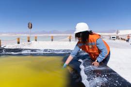 Fotografía de archivo fechada el 24 de octubre de 2022 de una trabajadora de la Sociedad Química y MInera de Chile (SQM) mientras muestra litio en salmuera, en San Pedro de Atacama (Chile).