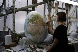 Un artista pinta un globo terráqueo en un estudio de Londres, el 27 de febrero de 2024.