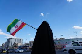 Una mujer ondea una bandera iraní durante una campaña en apoyo al gobierno en la plaza Enqelab-e-Eslami, o Revolución Islámica, en el centro de Teherán, Irán.