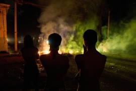 Varias personas observan una barricada levantada por residentes que protestan contra los prolongados cortes de electricidad en La Habana, Cuba, informó la agencia AP en campo.