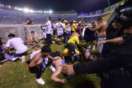 Fanáticos auxilian a personas durante una estampida en el Estadio Cuscatlán previo a un partido de la Liga Mayor.