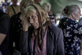 Una mujer evacuada de una aldea en la región de Donetsk, atacada por las fuerzas rusas que avanzan, espera para registrarse para recibir ayuda humanitaria en Pavlograd, Ucrania.