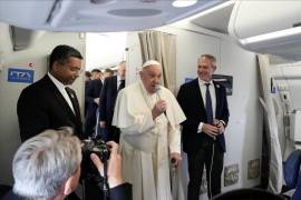 El Papa Francisco (c), flanqueado por su portavoz Matteo Bruni (D), habla con los periodistas a bordo del vuelo con destino a Yakarta, primera escala de su viaje apostólico al sudeste asiático