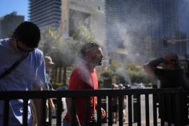Personas se refrescan con los aspersores a lo largo del Strip de Las Vegas, el domingo 7 de julio de 2024, en Las Vegas.