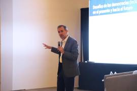 En su conferencia afirmó que el país se encamina hacia el autoritarismo, pues los ataques a la democracia provienen ahora desde el propio poder político y no de golpes militares.